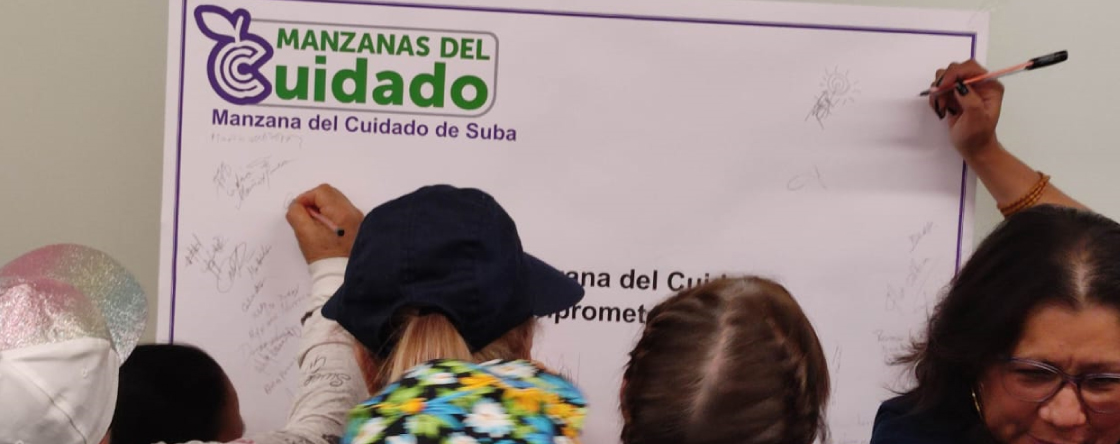 Personas firmando los Pactos por las Manzanas del Cuidado