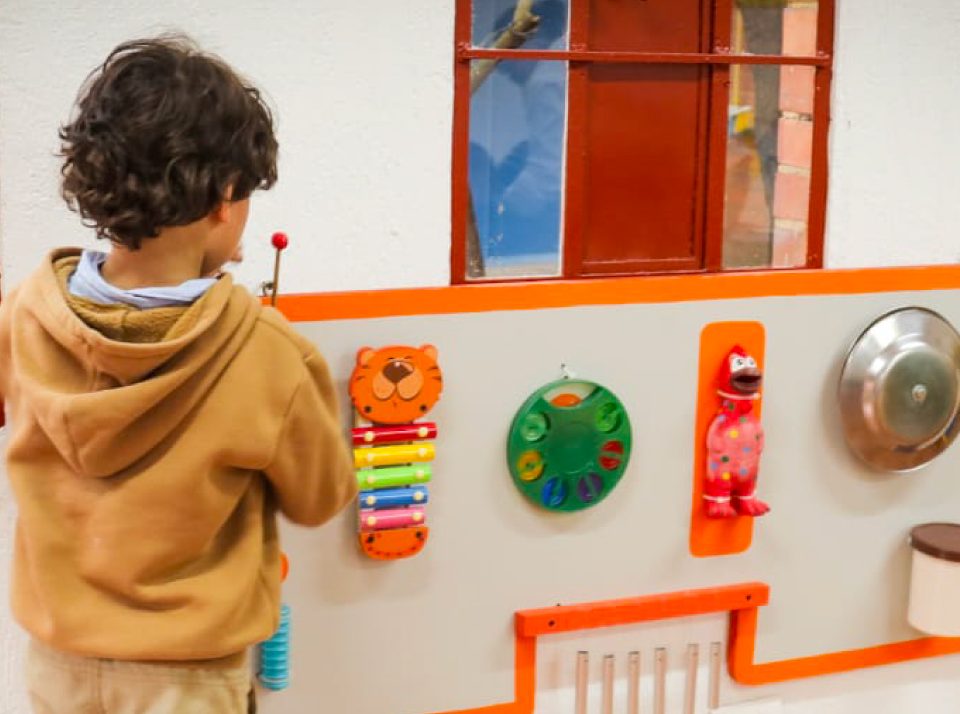 Niño jugando con actividades para infantes en manzana del cuidado