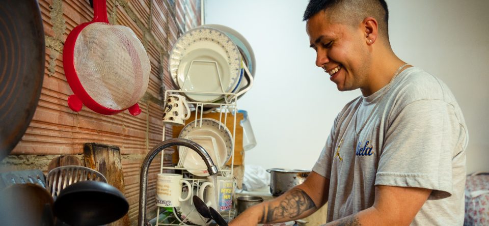 Hombre lavando platos responsable de trabajo de cuidado
